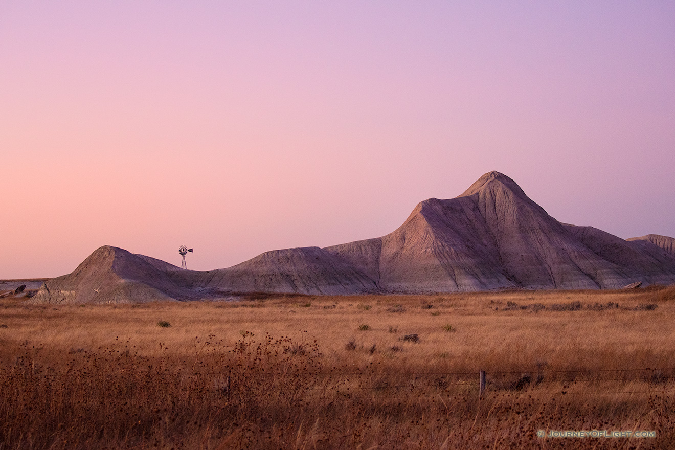 Scenic landscape photograph of a windmill and badlands during dusk in western Nebraska. - Nebraska Picture