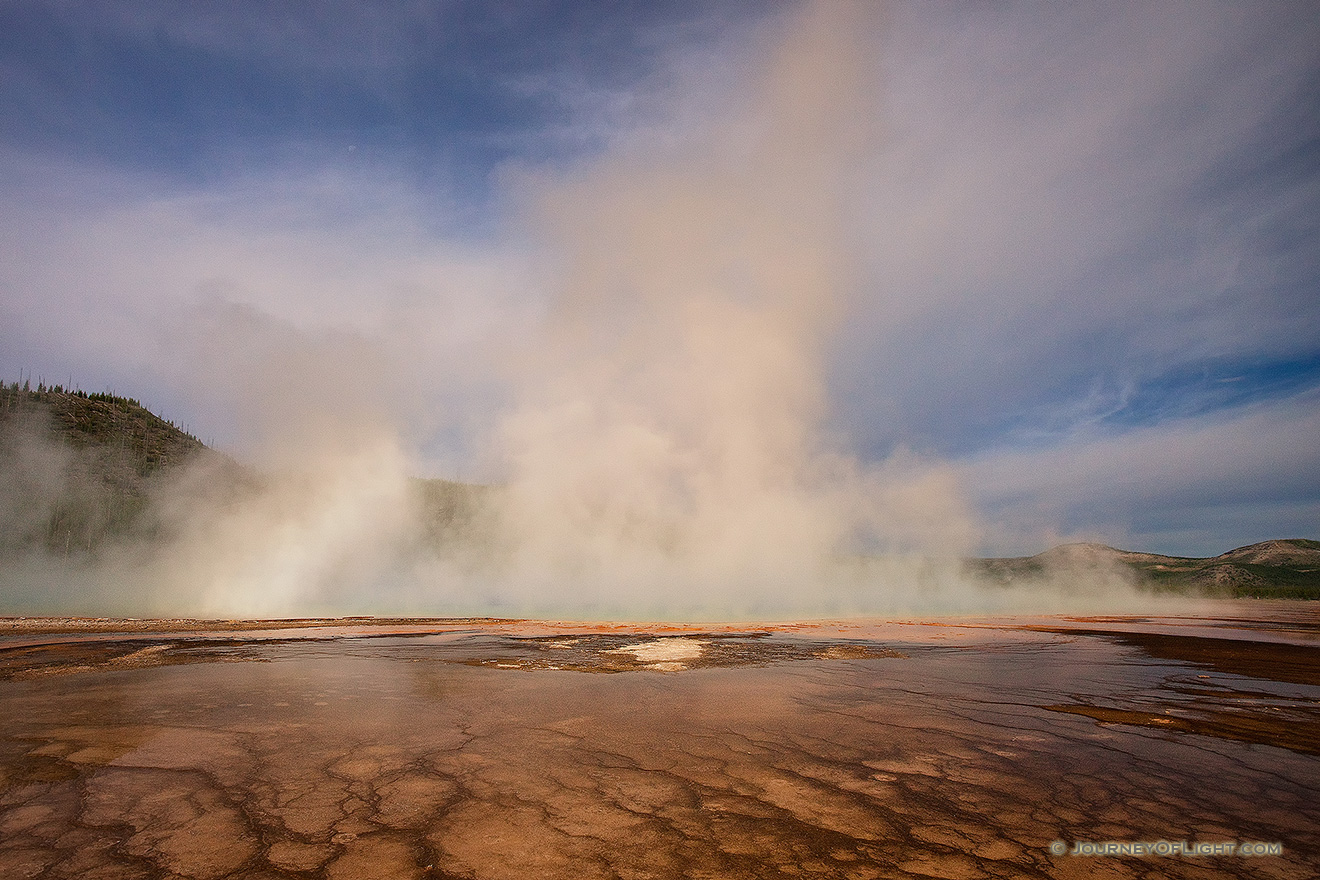 Steam from the Grand Prismatic Spring in the Middle Geyser basin rises with a warm hue from the early morning sun. - Yellowstone National Park Picture