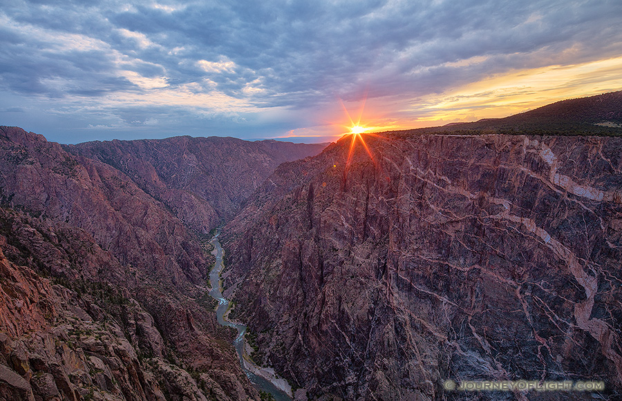 The last bit of sun hangs just above the canyon wall at Black Canyon of the Gunnison National Park on a cool summer evening. - Colorado Photography