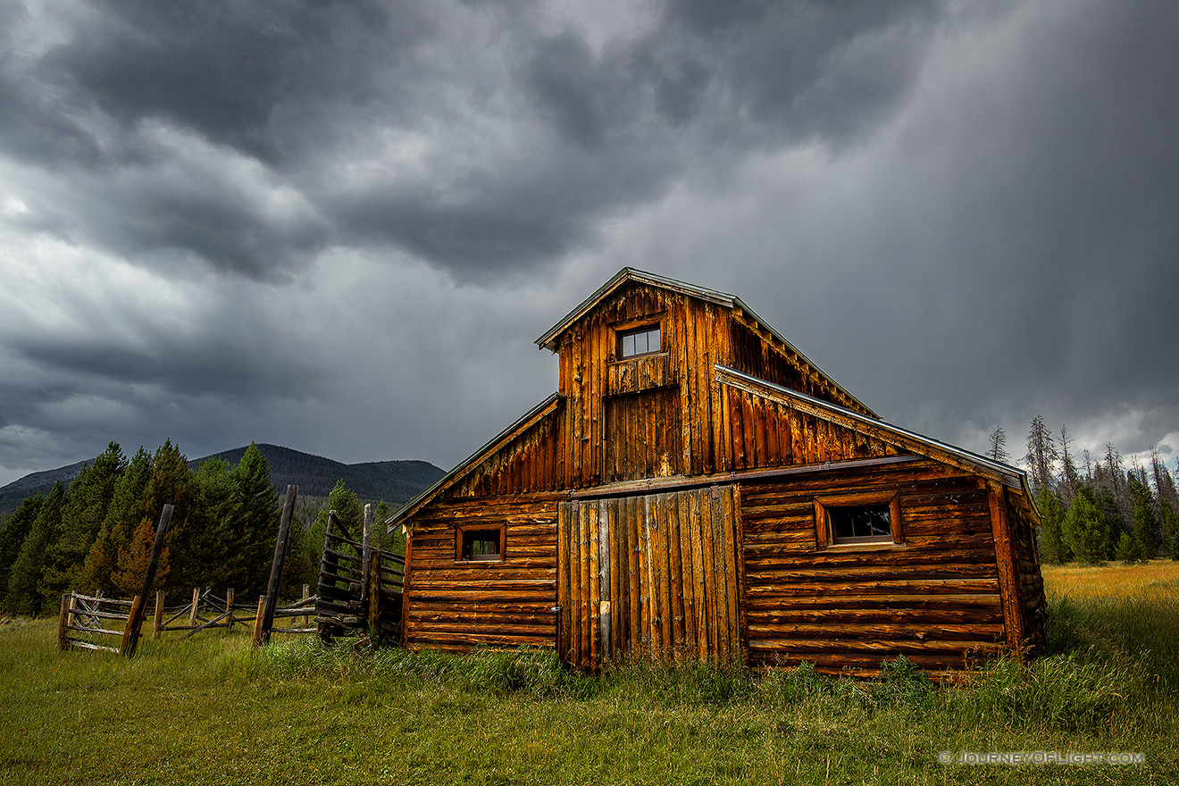 Under stormy clouds, a wooden barn sits in the Kawuneeche Valley on the western side of Rocky Mountain National Park in Colorado. - Colorado Picture