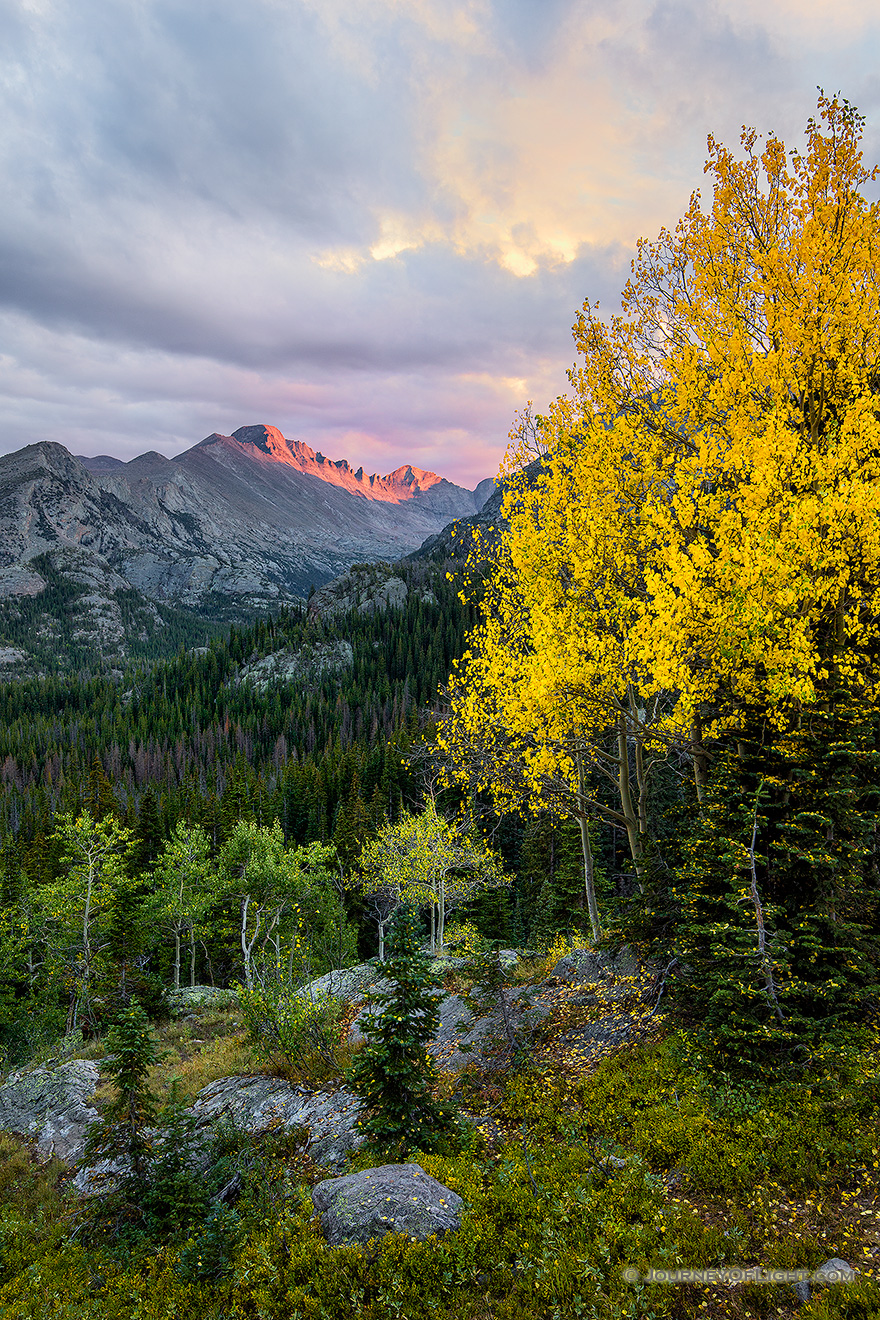 After a brief rainfall, on a cool autumn evening the last  bit of sun illuminates the peak of Long's Peak in Rocky Mountain National Park. - Colorado Photography