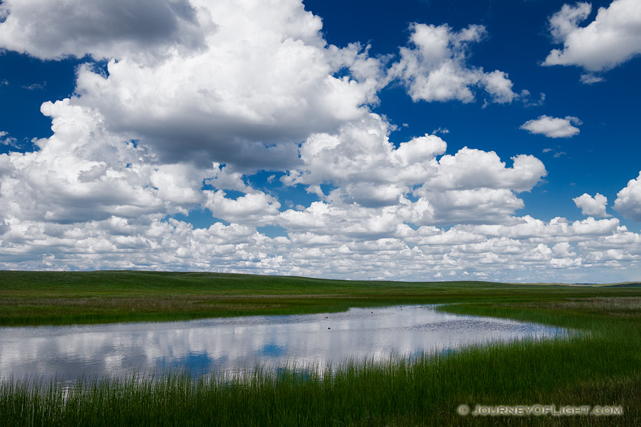 Clouds float lazily above a lake in the Sandhills of Nebraska. - Nebraska Photography