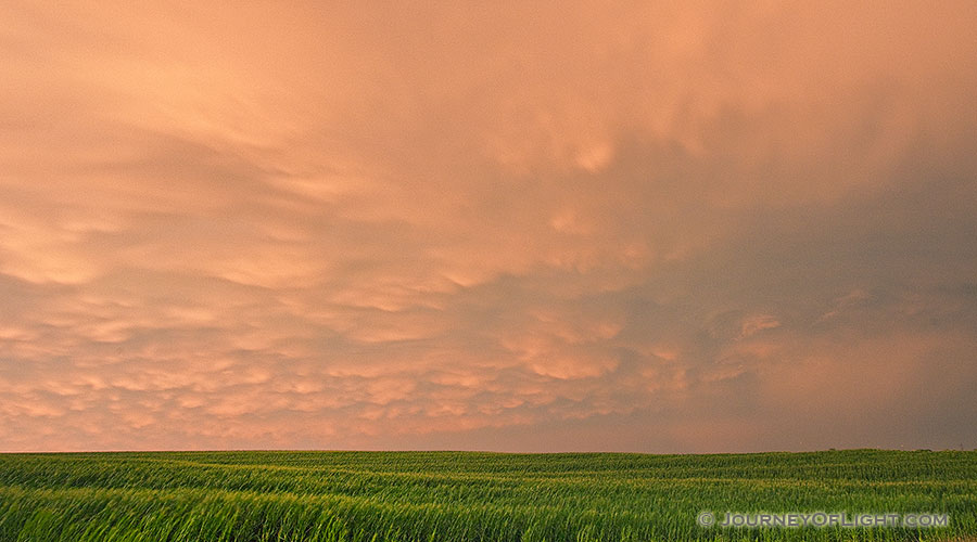 Passing ominous storm clouds reflect the red and orange hues of the sun 45 minutes after sunset. - Nebraska Photography
