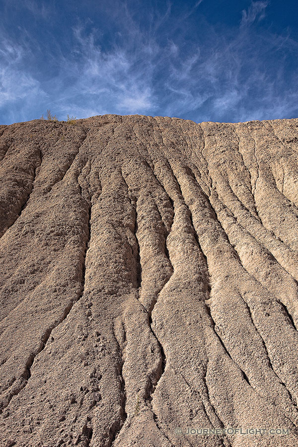 Clouds float lazily over the eroded hills at Toadstool Geologic Park. - Toadstool Photography