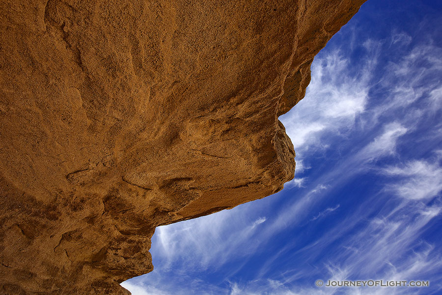 Clouds float lazily over the strange stone structures at Toadstool Geologic Park. - Toadstool Photography