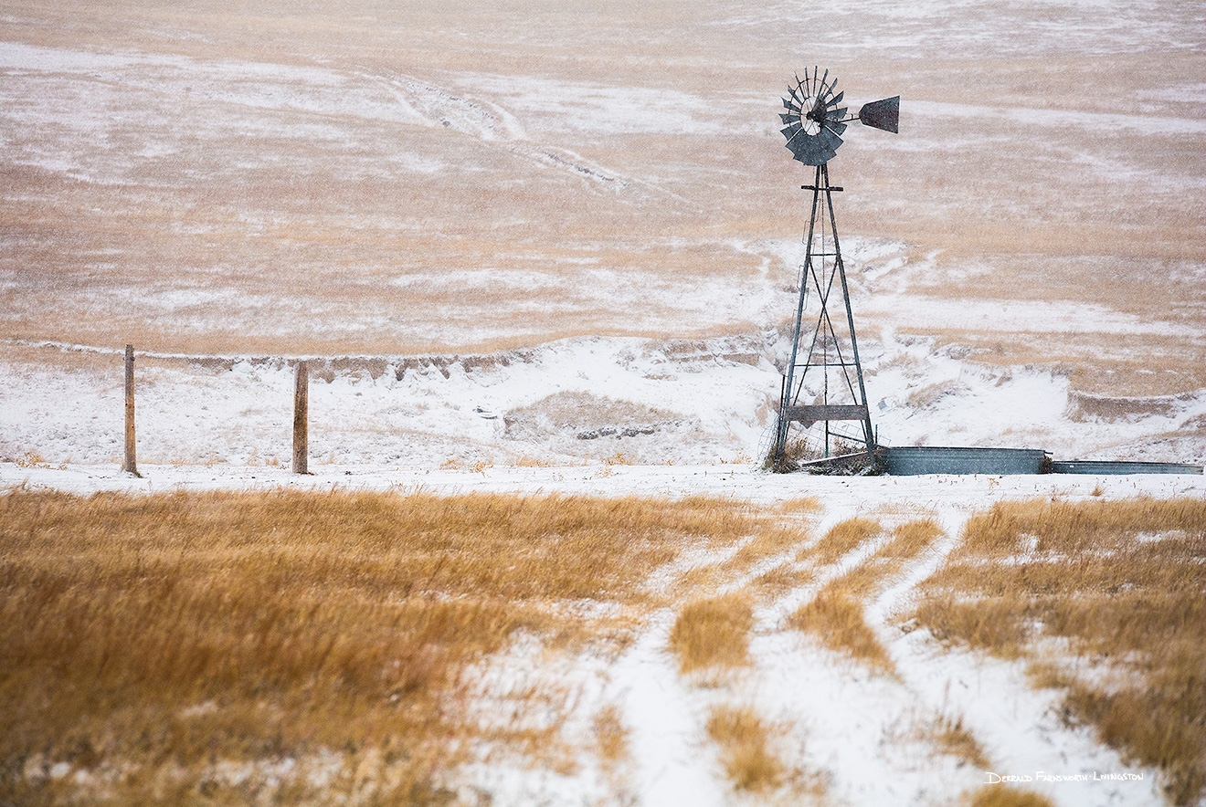 Scenic landscape panoramic photograph of a windmill and a road in the winter at Oglala National Grasslands. - Nebraska Picture