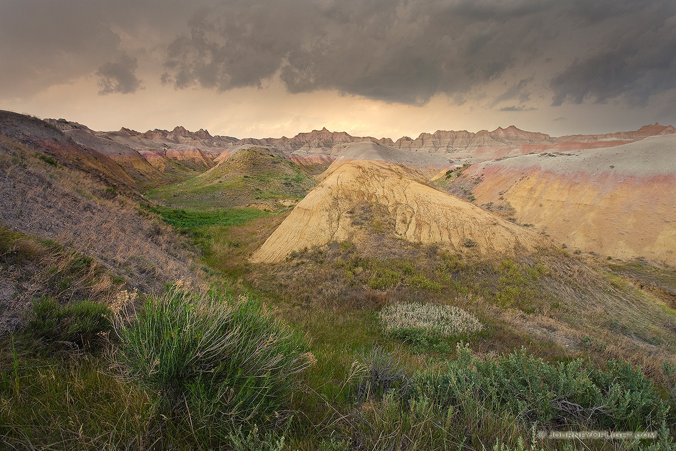 As a storm passes over Badlands National Park in South Dakota, the last light of the day illuminates a few distant clouds. - South Dakota Picture