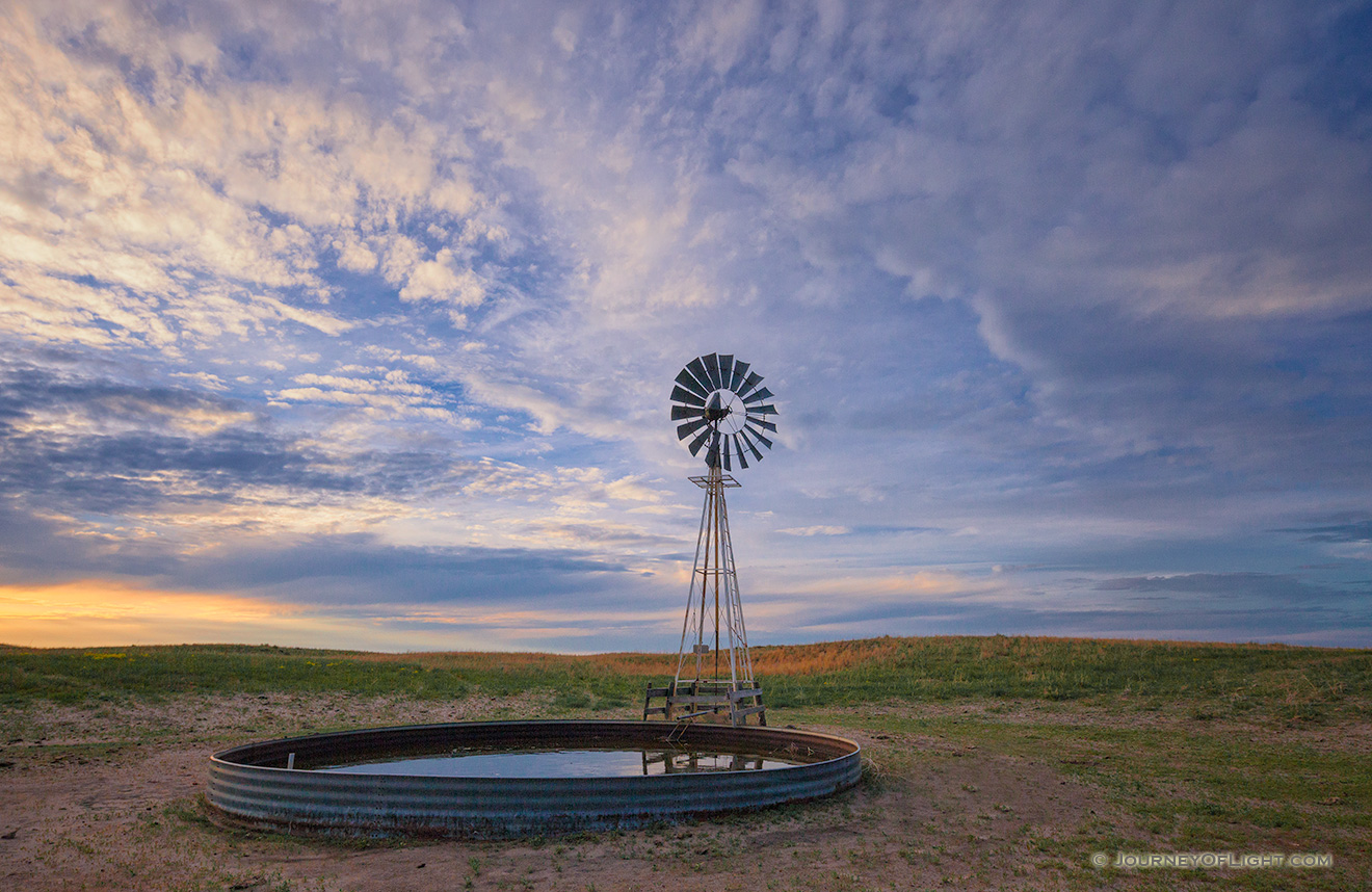 Dusk falls as clouds hover over a remote windmill in McKelvie National Forest in western Nebraska. - Sandhills Picture