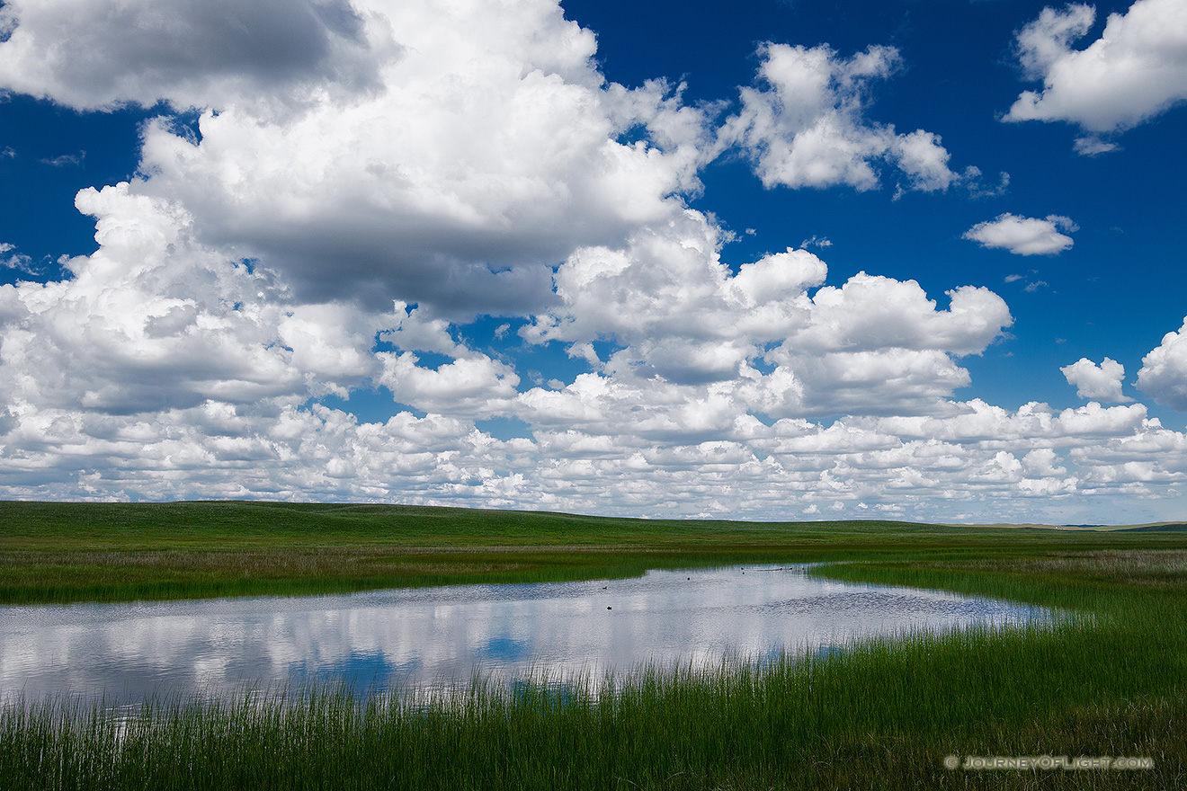 Clouds float lazily above a lake in the Sandhills of Nebraska. - Nebraska Picture