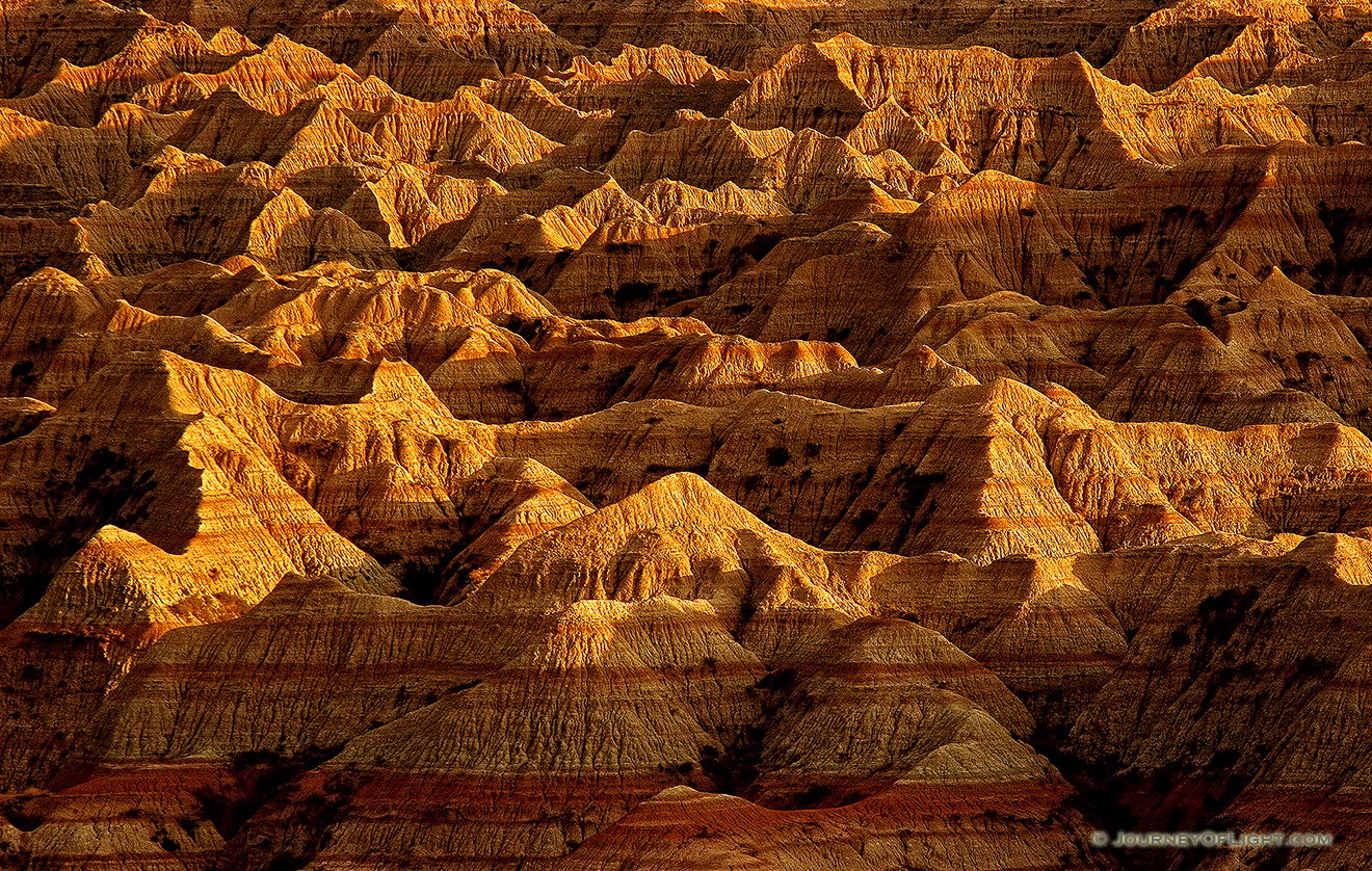 The late afternoon sun creates abstract shapes from the long shadows in the Badlands, South Dakota. - Badlands NP Picture