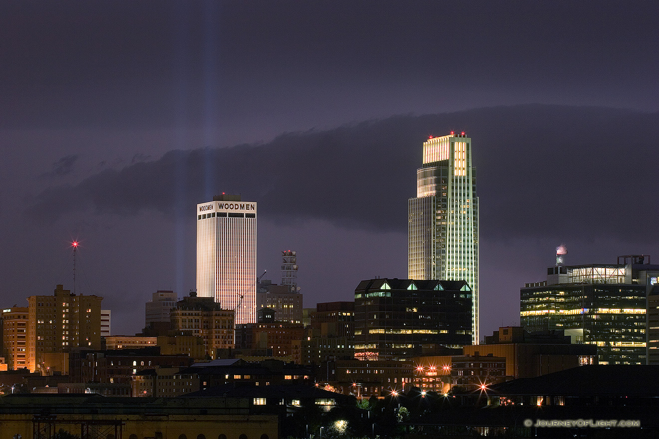 On September 11, 2006 Omaha, Nebraska paid tribute to the victims of 9/11 by hanging 2 large United States flags on the Woodmen tower and by shining two large lights into the sky.  This particular photo was taken during a spectacular fall lightning storm. - Omaha Picture