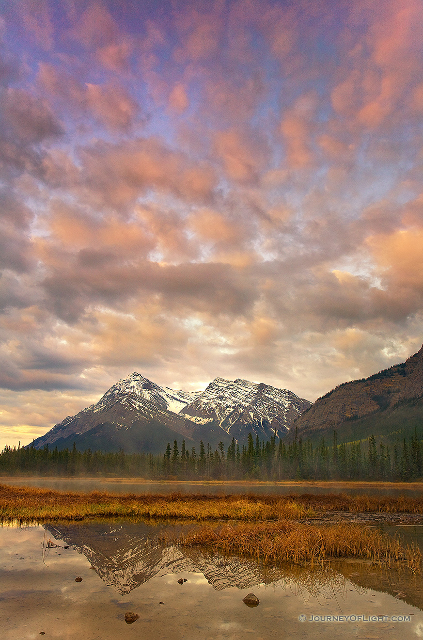 The first light illuminates the clouds above mountains on the Kootenay plains in Alberta, Canada. - Canada Picture