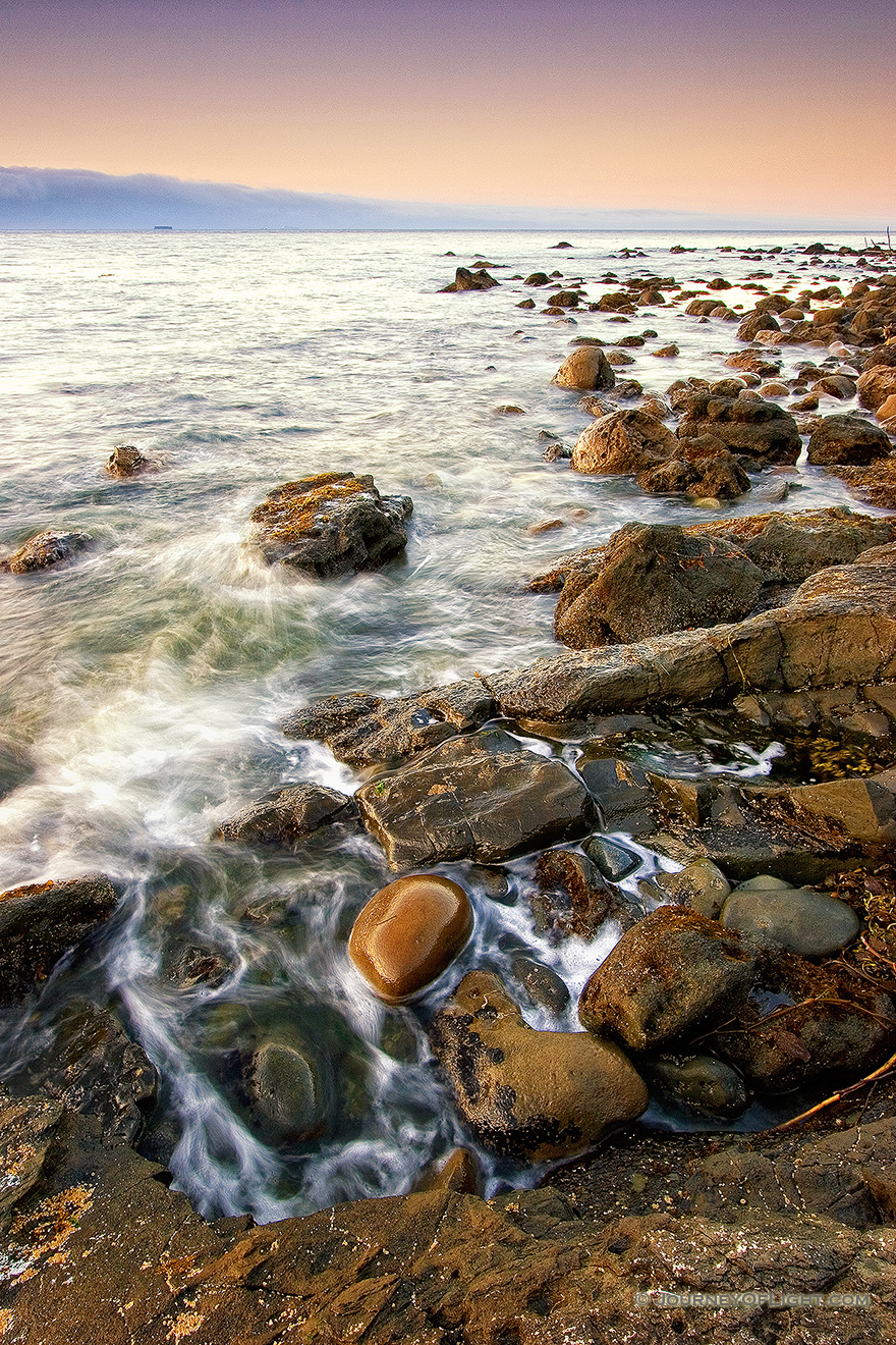 Close to the northwestern most tip of the continential United States, the waves of the Strait of the Juan de la Fuca lap against the rocks. - Pacific Northwest Picture
